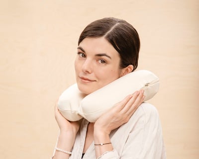 ragazza che usa il cuscino per il collo in lana per i viaggi