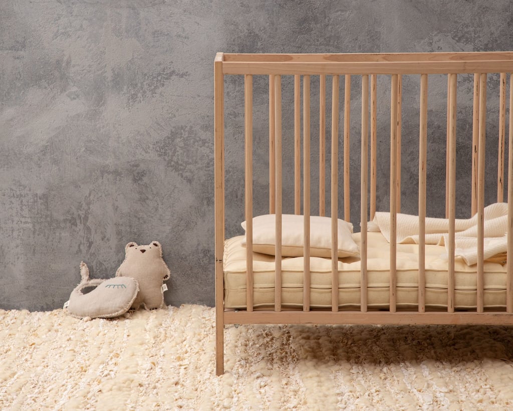 colchón en cuna sobre alfombra de lana hecha a mano con juguetes DIY de casa de lana