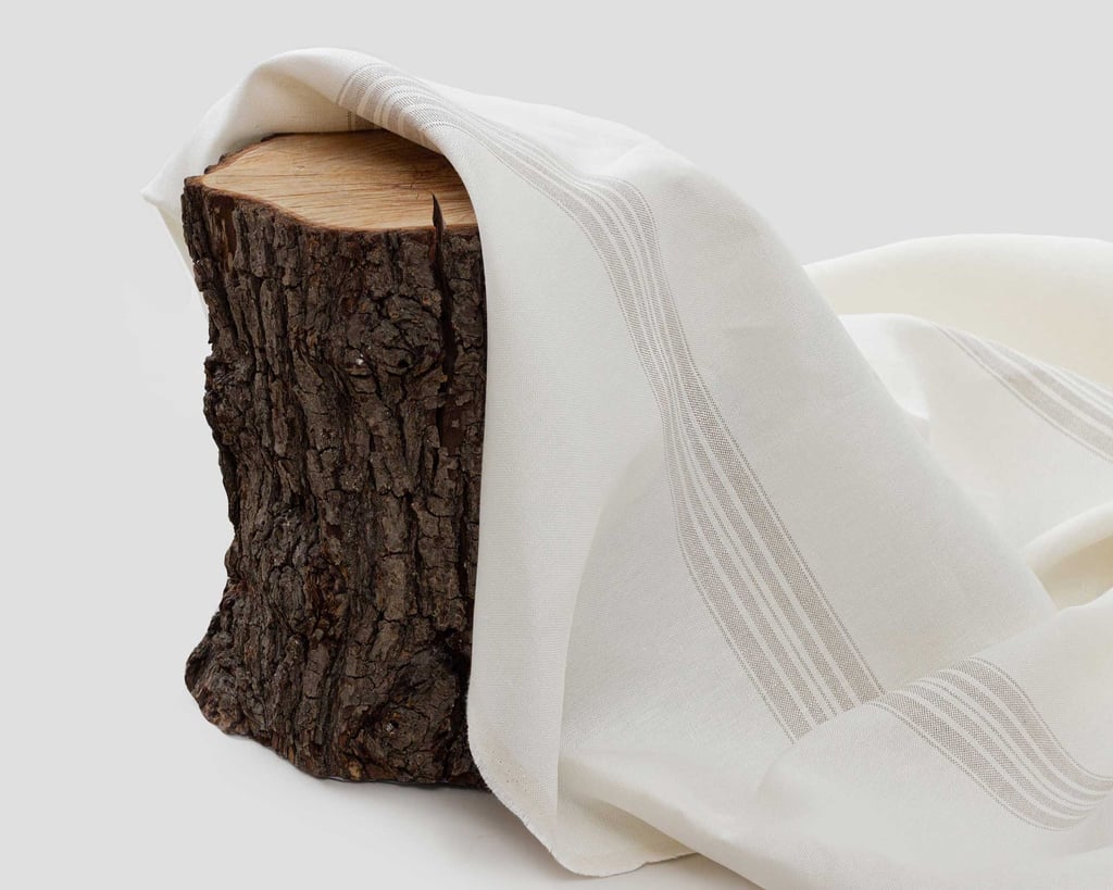 grey striped linen fabric in a setting with a piece of wood