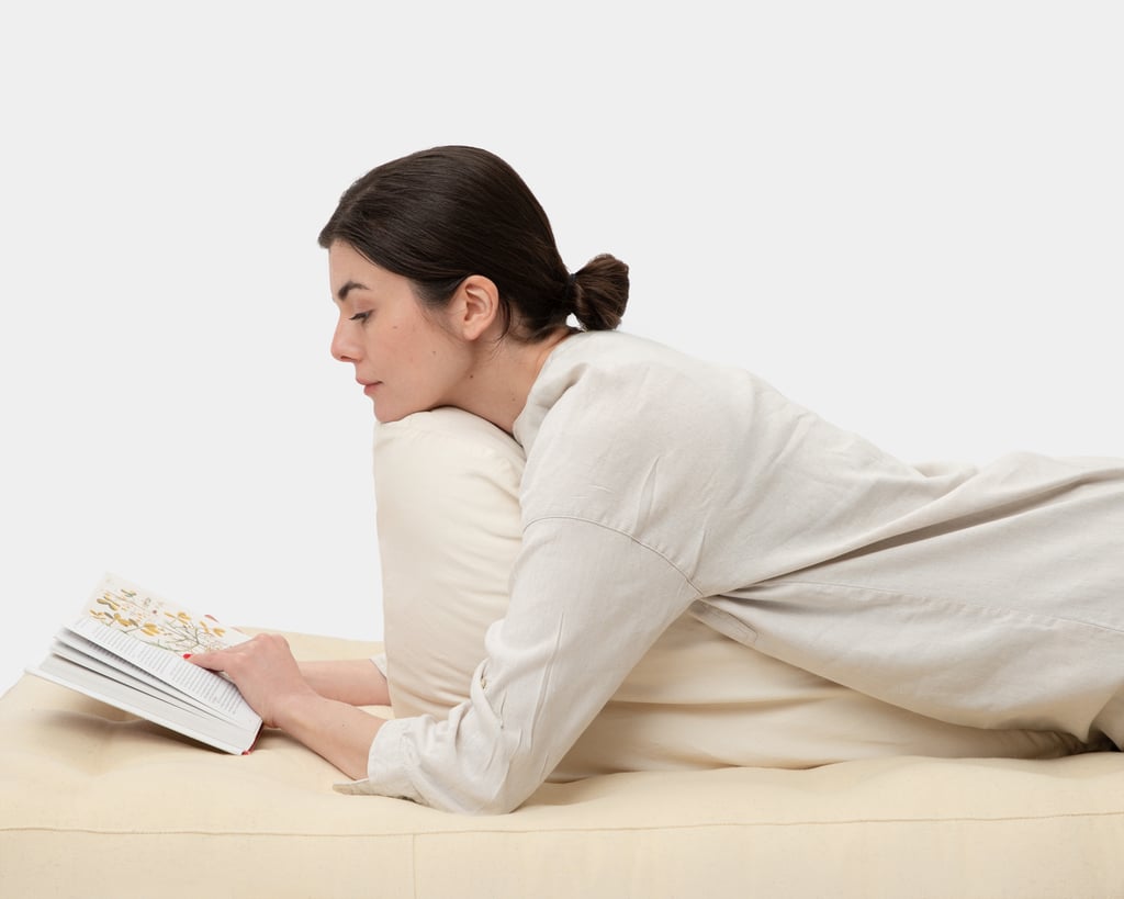 girl reading a book using home of wool reading pillow