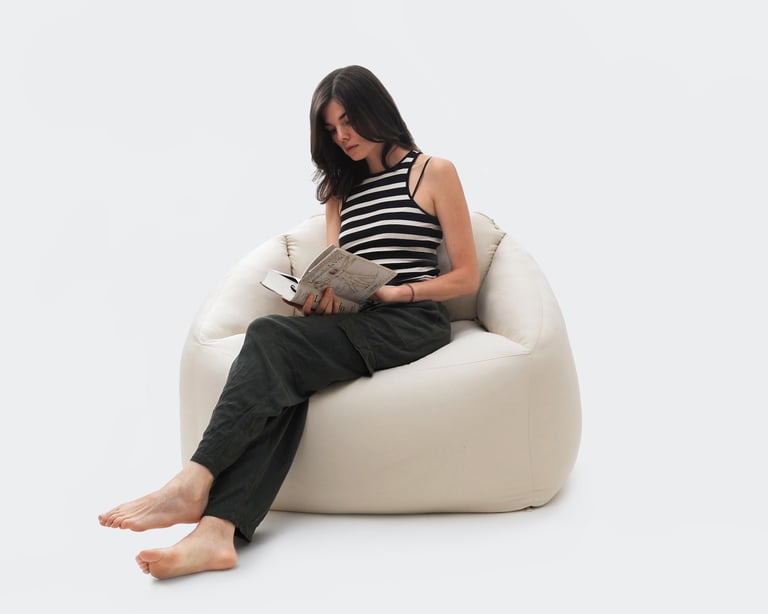 wool bean bag armchair with a woman sitting in it reading a book