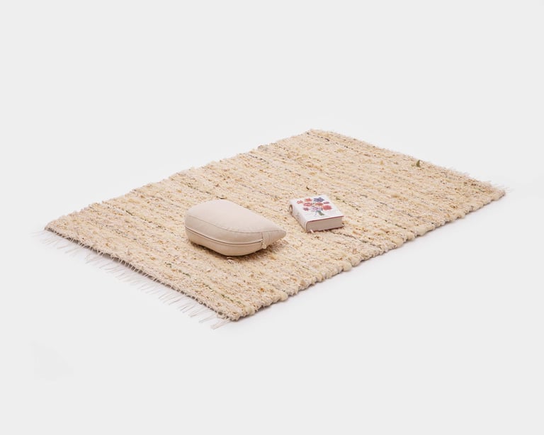 half moon zafu and book on top of rustic handwoven rug