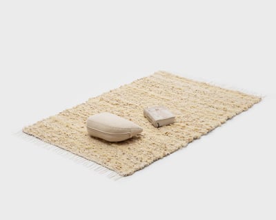 zafu de media luna y libro sobre una moderna alfombra de lana