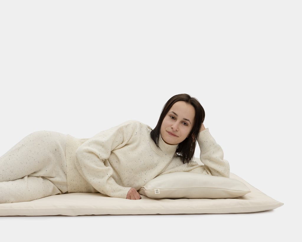 a woman leaning on a pillow and standing on a woolen sleeping floor mat home of wool
